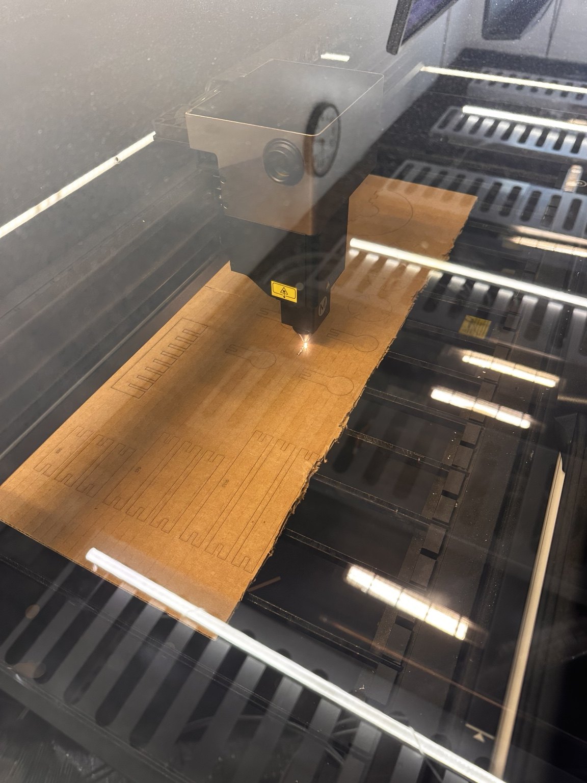 Laser cutter working on the cardboard construction-kit sheet
