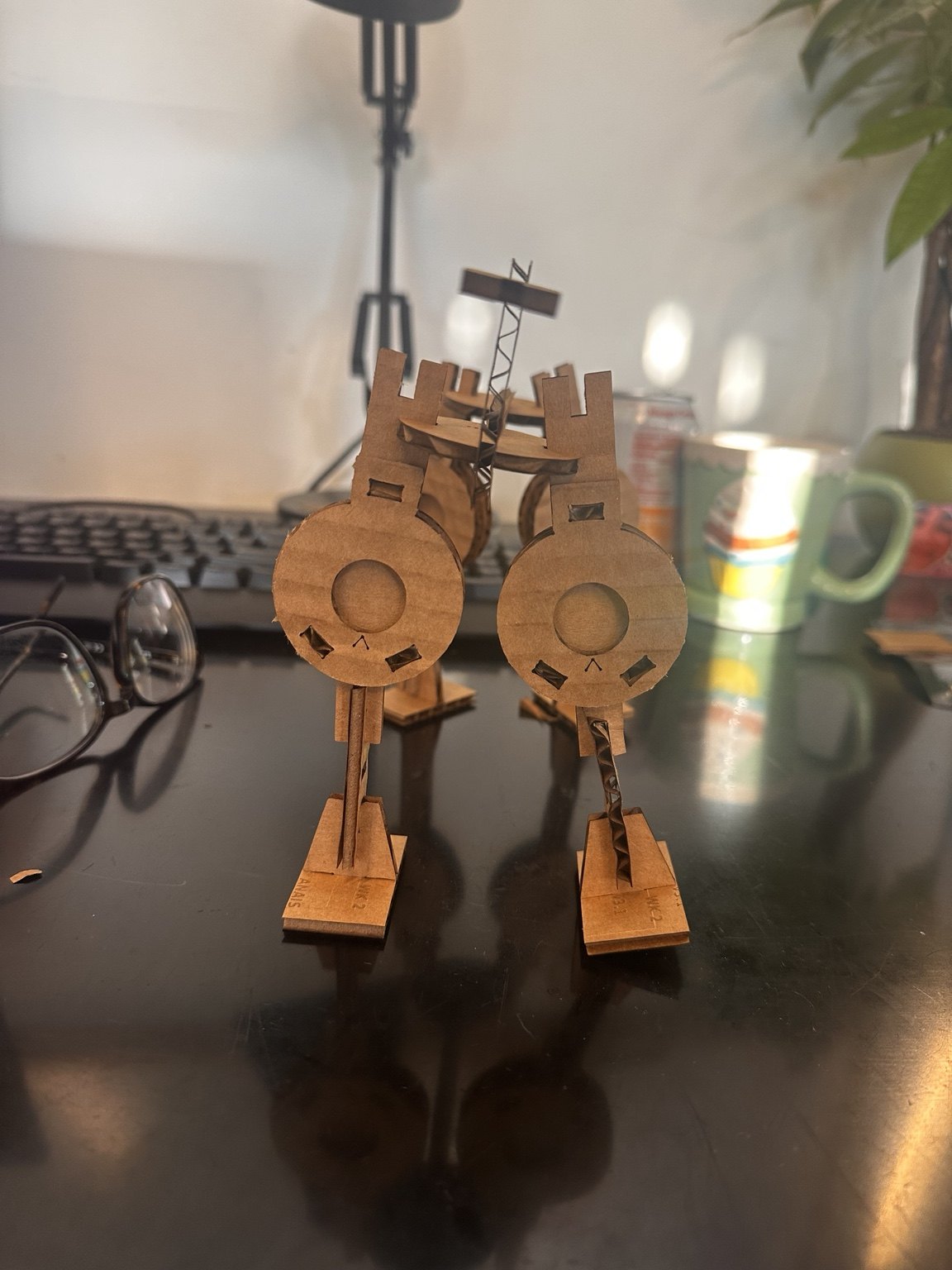 Completed cardboard quadruped seen head-on, standing on a desk