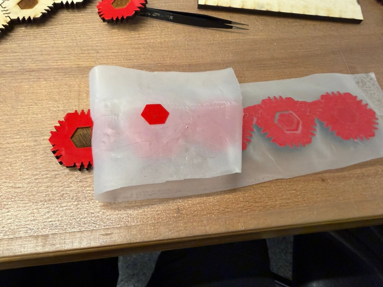 Peeling away the transfer paper to stick the red vinyl