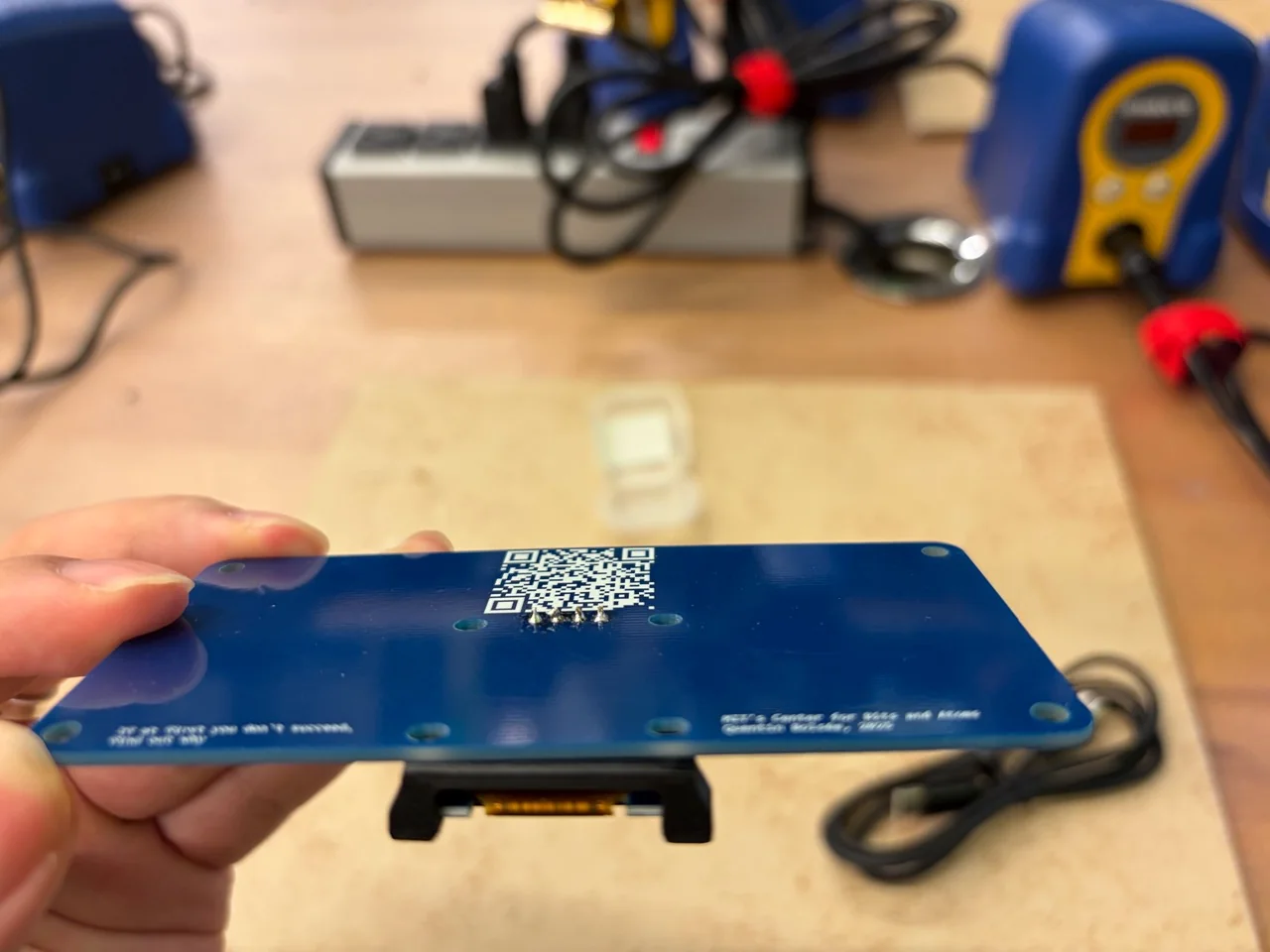 Back of the QPAD PCB showing rear solder joints and the OLED projecting below the board