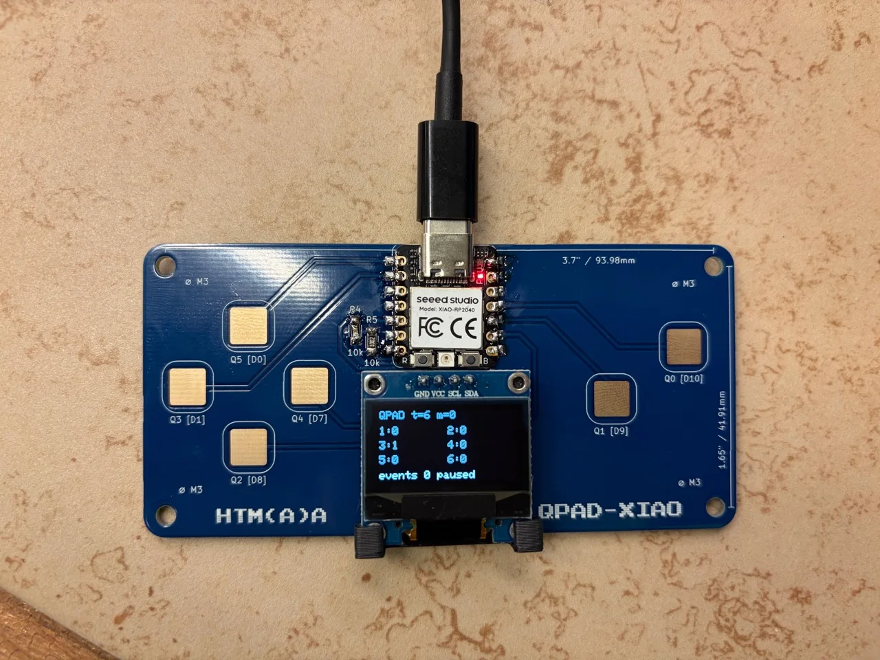 USB-powered QPAD with diagnostic text visible on the OLED