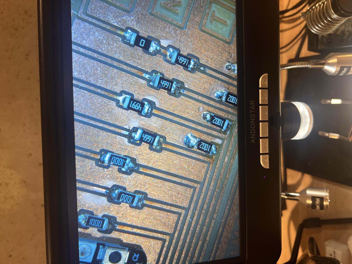 Resistors under the microscope: 1000 (100 Ω), 4991 (4.99 kΩ), 1002 (10 kΩ) and the 0 Ω jumper