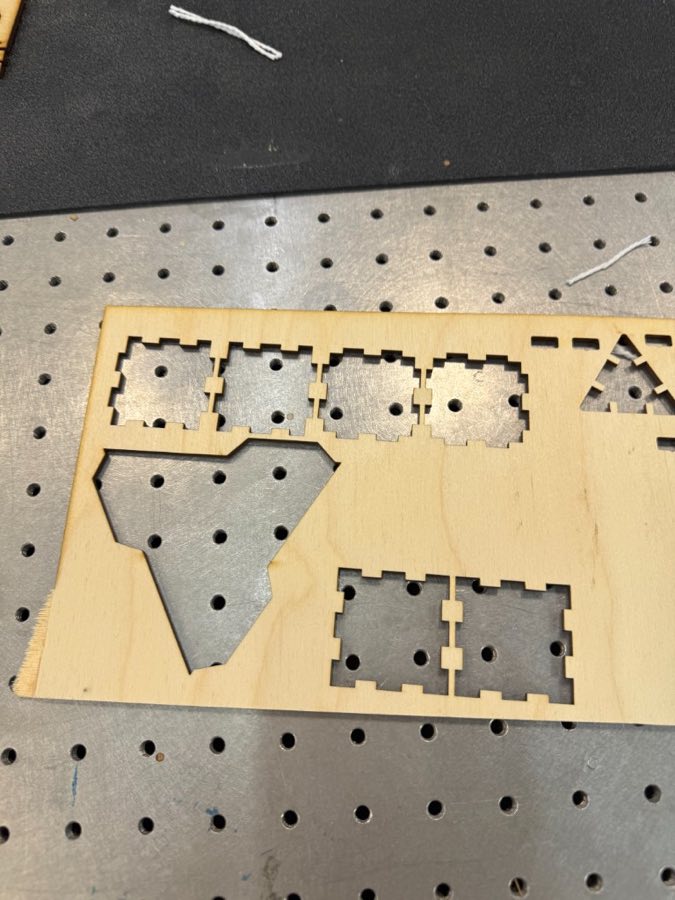 Failed laser-cut triangle version still sitting in the plywood sheet