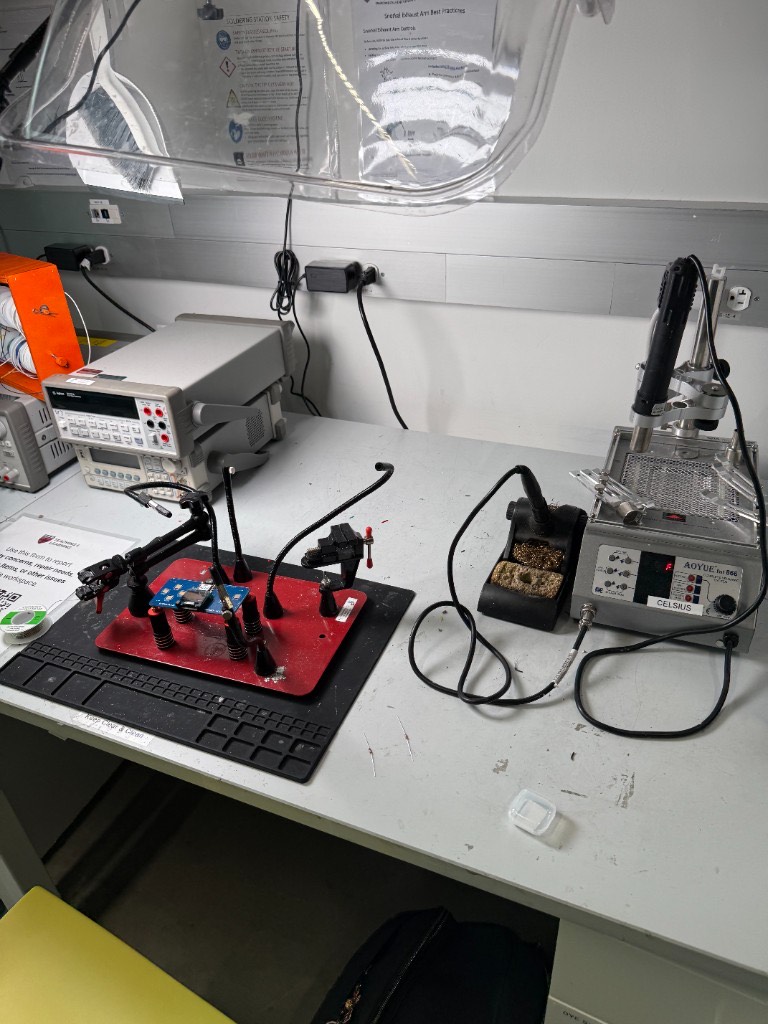 REEF soldering bench at Harvard with helping hands holding a blue board