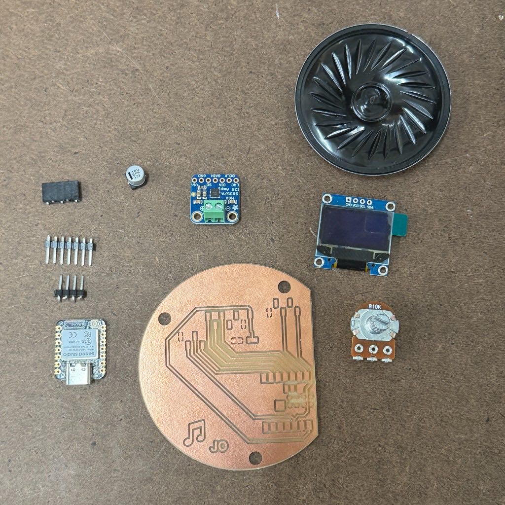 Milled board surrounded by its components: the XIAO, pin headers, capacitor, amplifier, OLED screen, potentiometer, and speaker