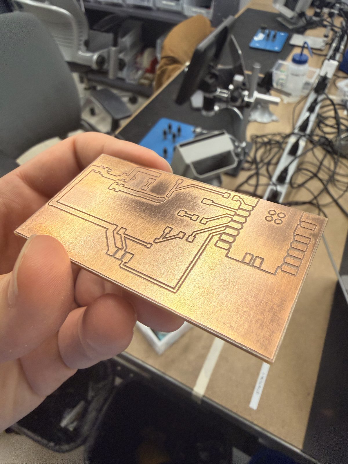 Milled board held over the bench, before soldering