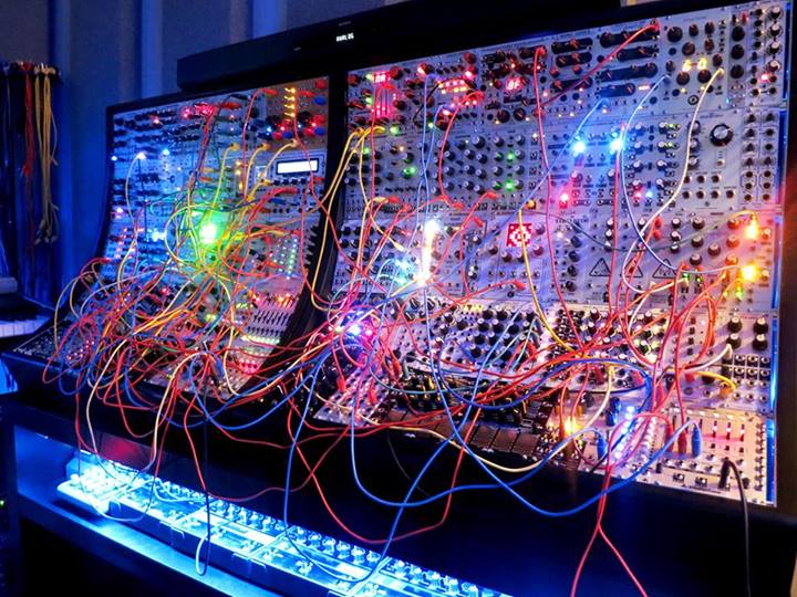 A Eurorack modular synthesizer case filled with modules and criss-crossed with patch cables
