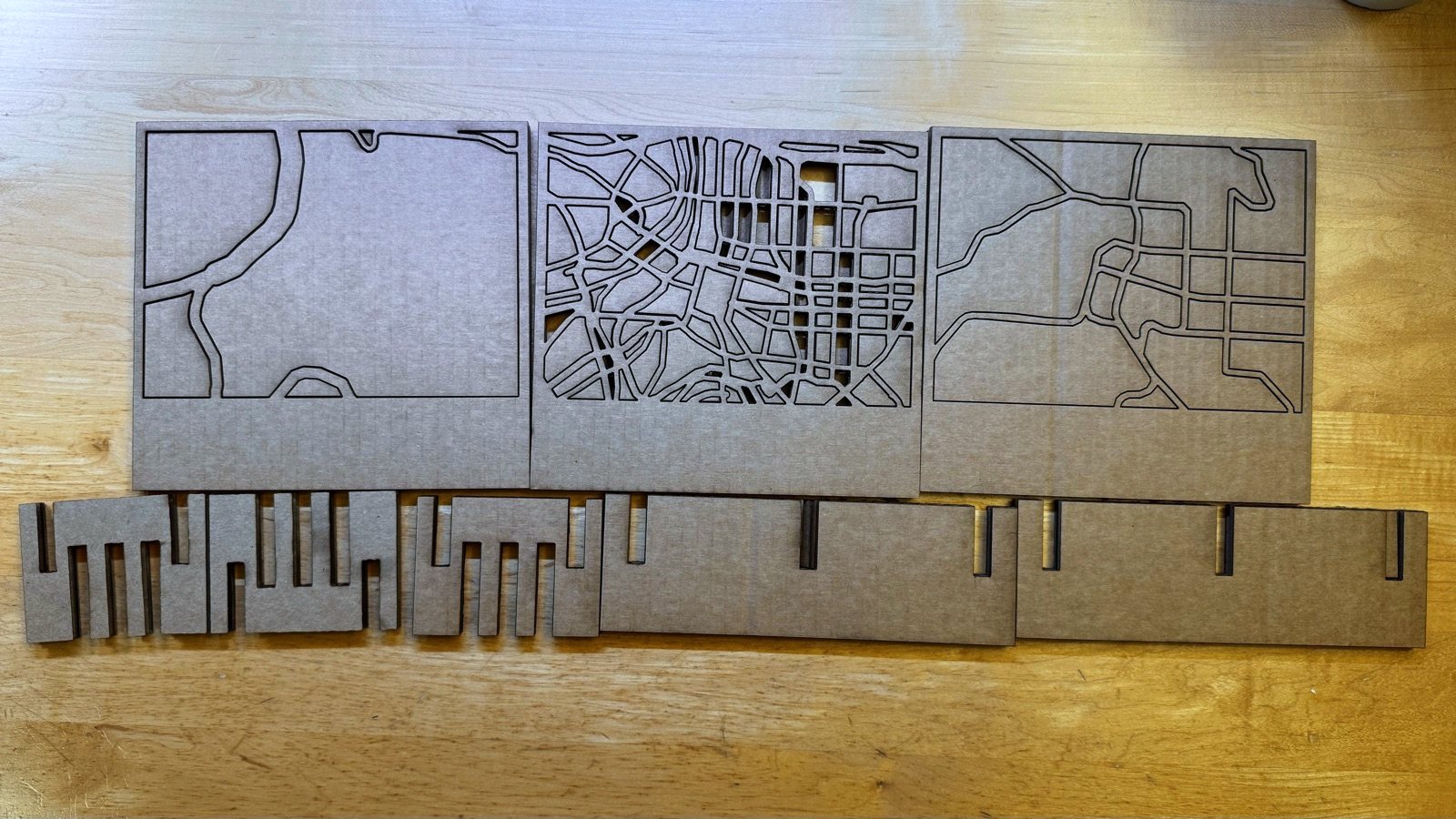 Three cut-through map plates of Taipei above the slotted rails and ribs