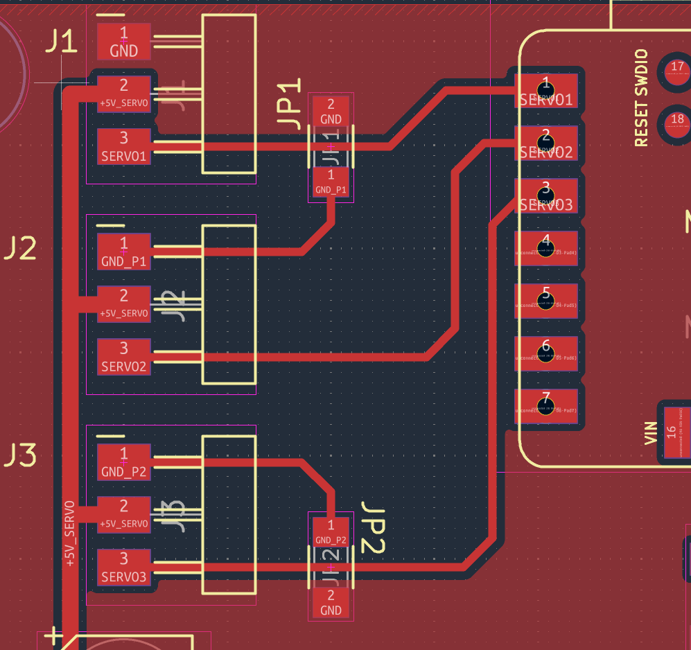 Close-up of the PCB: JP1 and JP2 sit on the signal traces of J1 and J3, linking GND_P1 and GND_P2 to GND