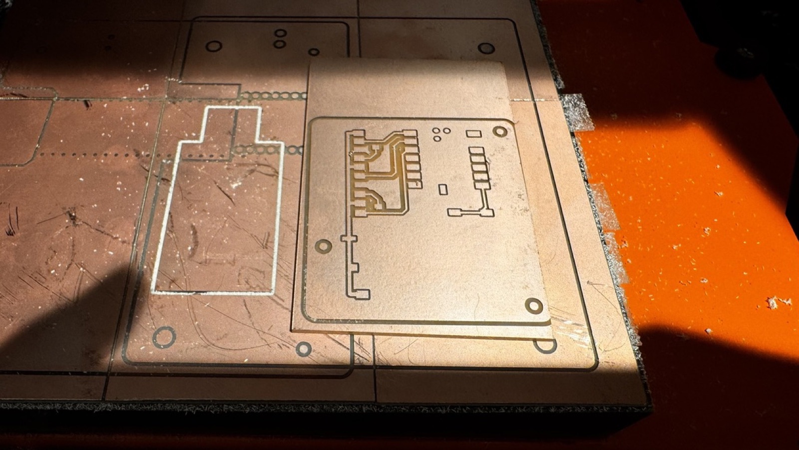Version 1 board on the machine bed after the first milling, with the traces cut