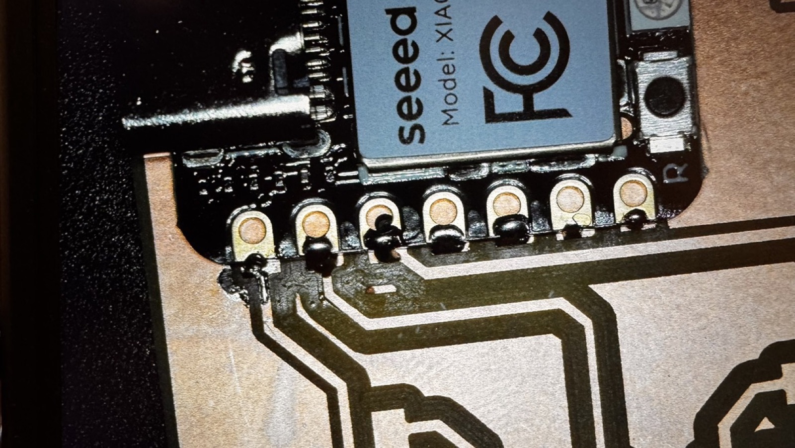 Microscope view of the XIAO pads soldered onto the traces of the board