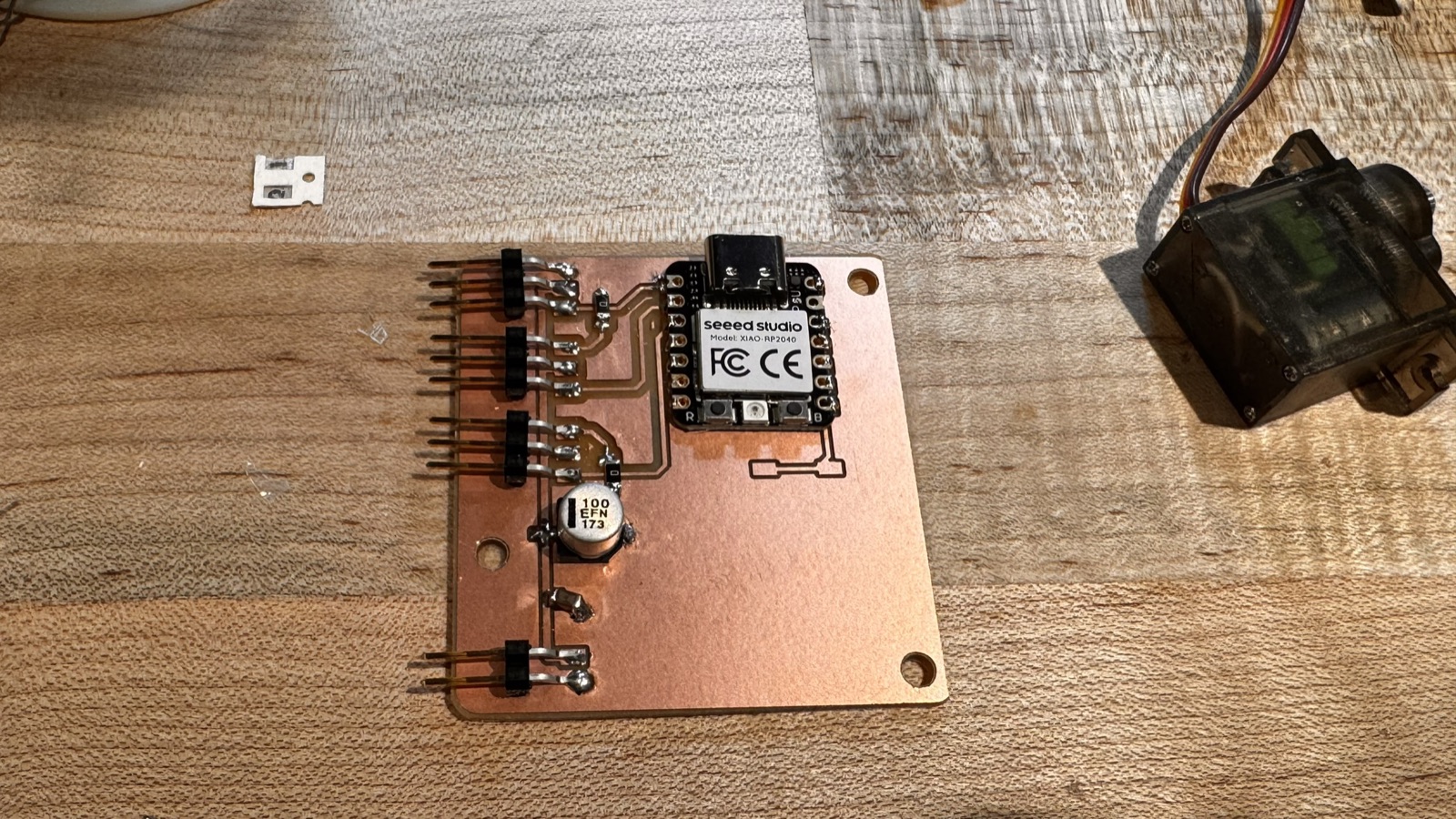 Version 1 board with the XIAO, four headers, the 100 microfarad capacitor and two jumper resistors soldered on