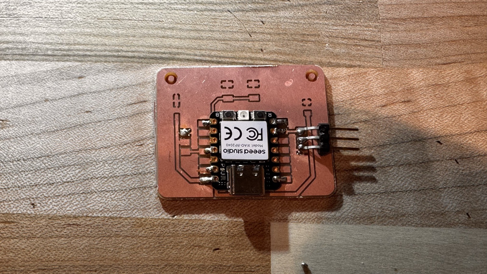 The latest version 2 board with the XIAO soldered in place and a three-pin header at the bottom edge