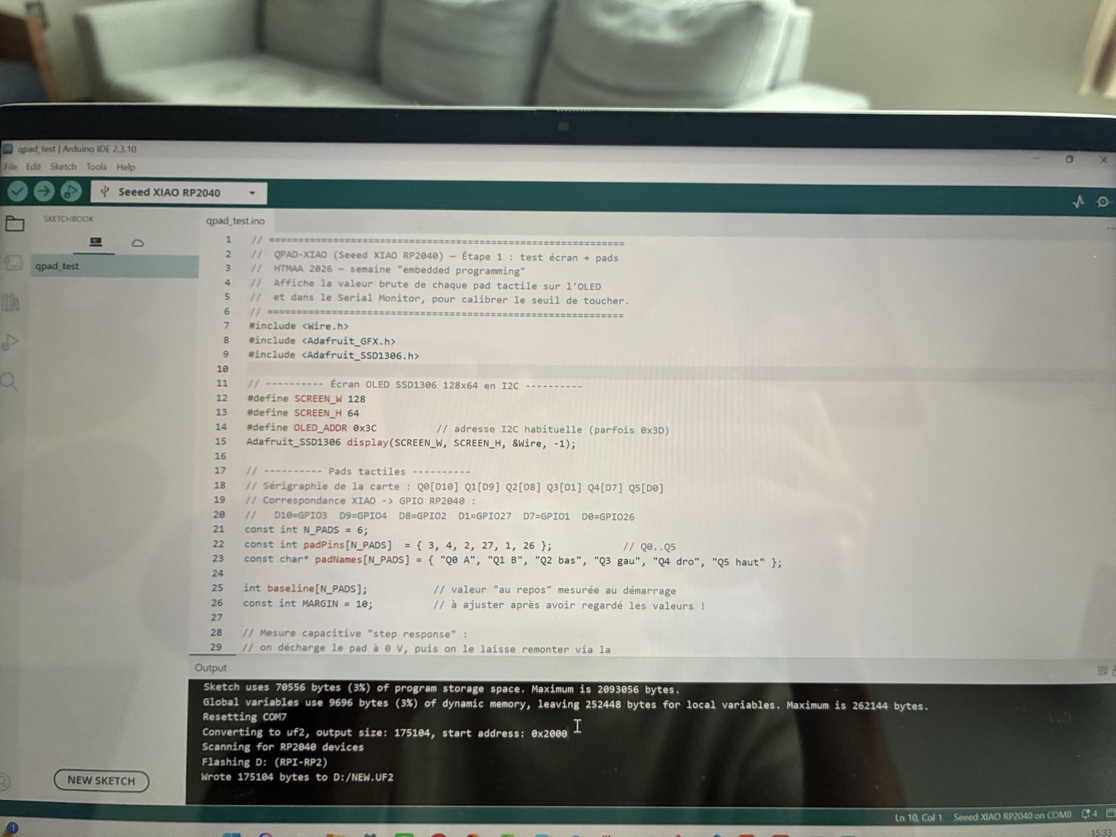 Laptop screen with the Arduino IDE showing the qpad_test source code and, in the output pane, the successful upload log reporting flash and RAM usage and writing the UF2 file to the RPI-RP2 drive