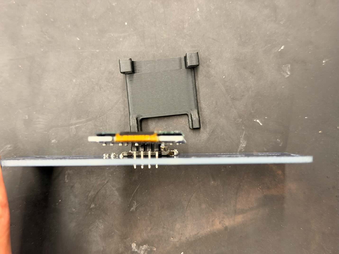 Side view of the soldered OLED with its separate holder behind it