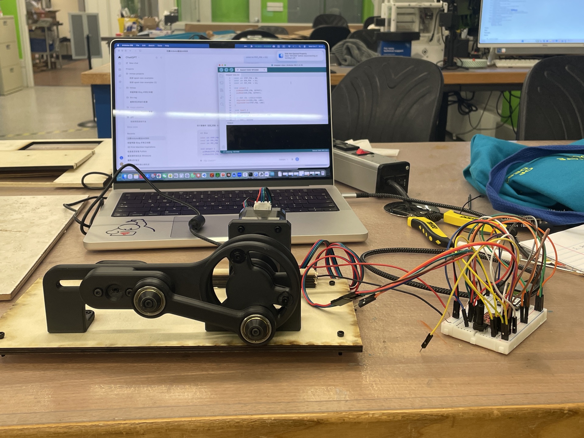 The mechanical structure, stepper motor, and breadboard prototype that motivated this PCB
