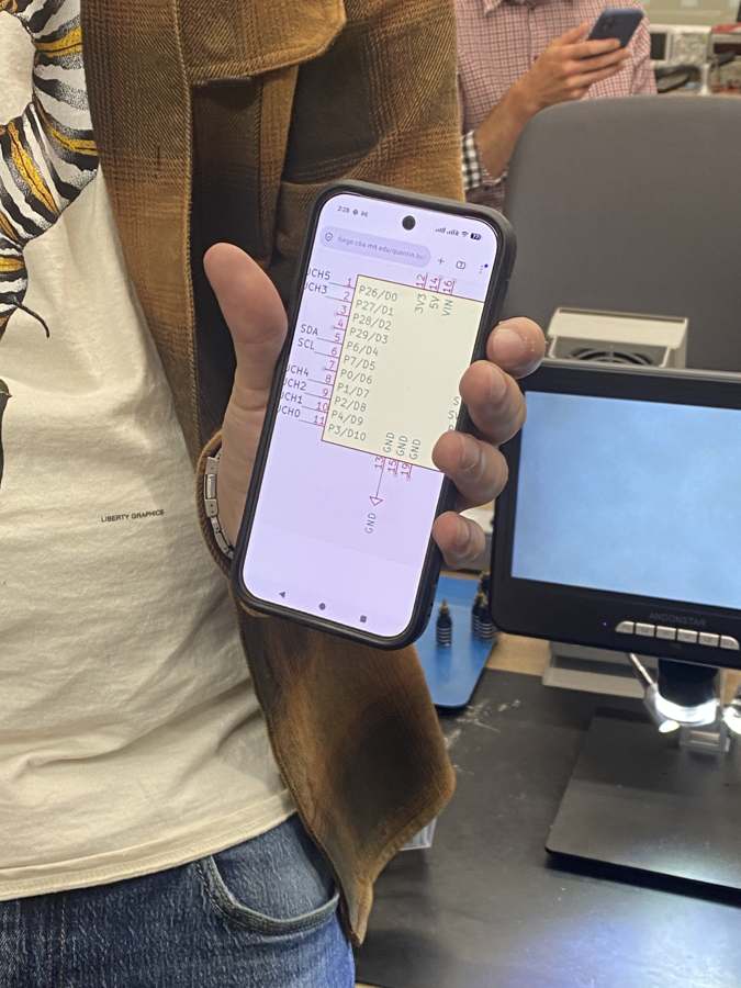 Quentin holding up his phone with the QPad schematic