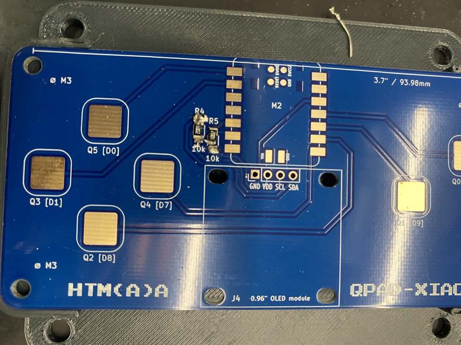 The bare QPad board with the two 10k resistors R4 and R5 soldered next to the XIAO footprint