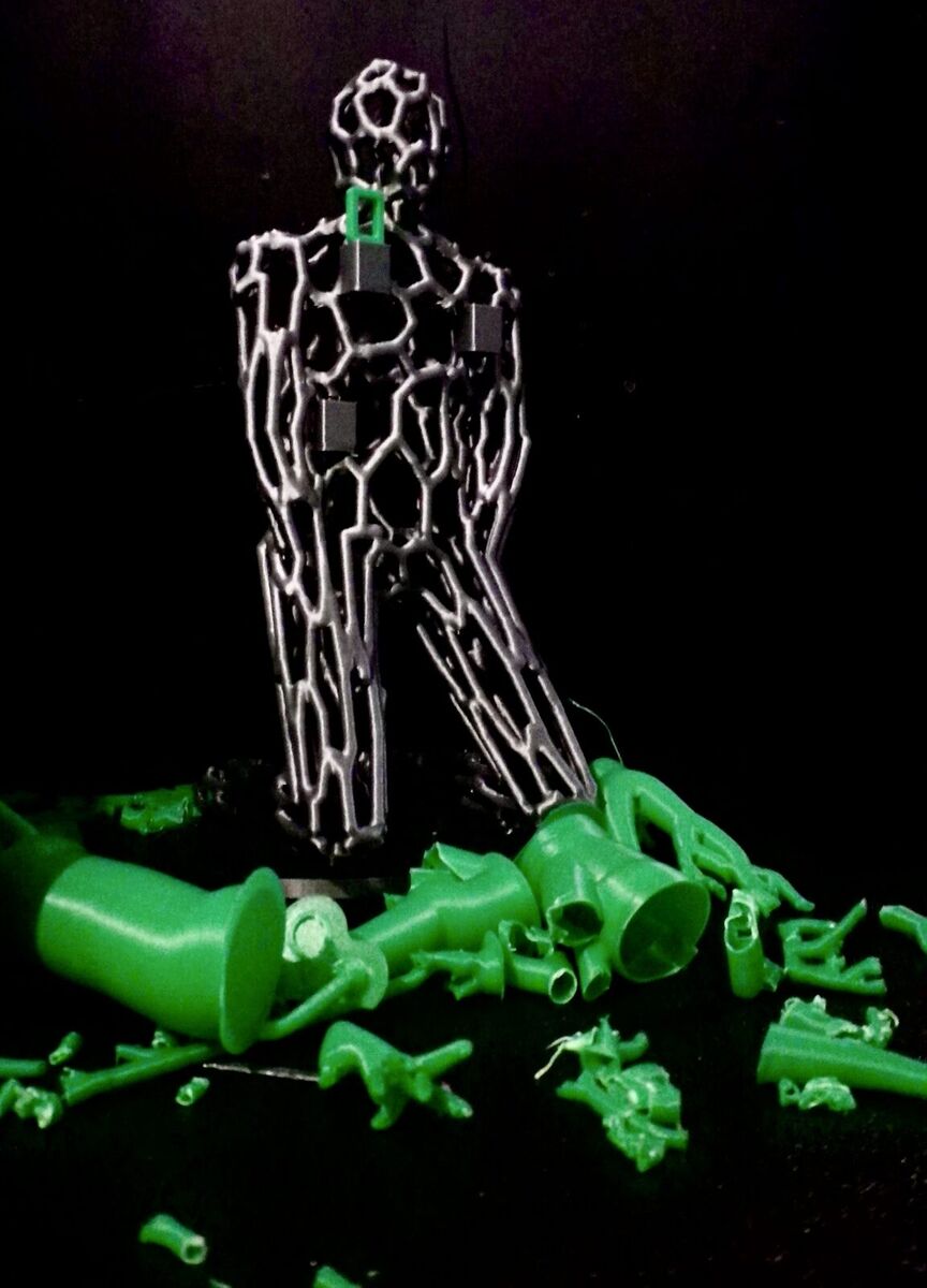 The gray lattice figure on a black background with a pile of green supports at its feet