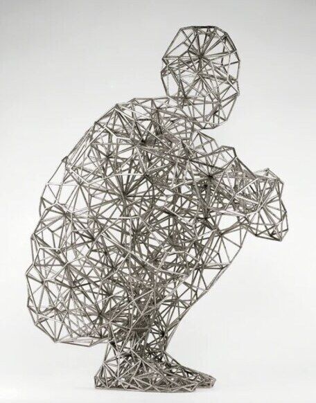 A crouching figure by Antony Gormley made of welded steel rods
