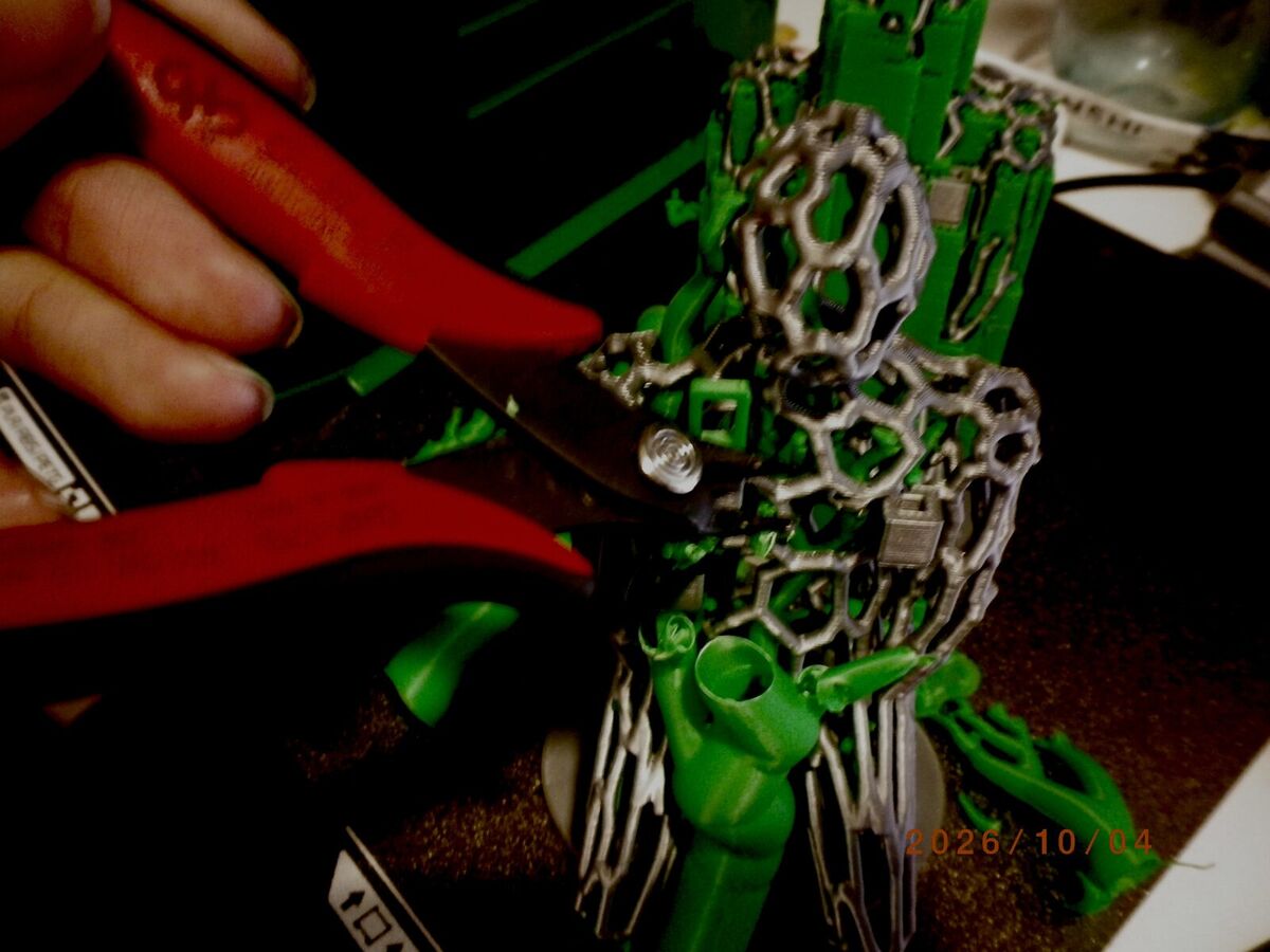 Cutting a green support branch away from the gray lattice with red flush cutters