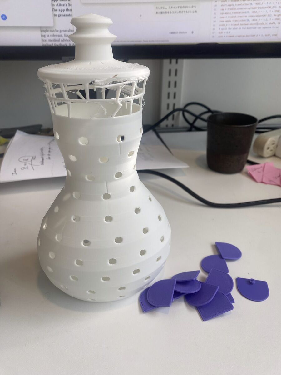 The white mannequin on a desk with loose purple scales beside it